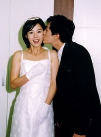 So Ji-Sub kissing Kim Hyun Joo on her cheeks. Kim Hyun in white bridal dress and So Ji in black suit.